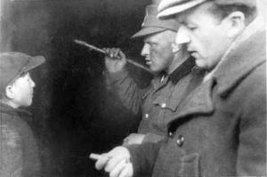 "
ילד יהודי בחקירה ברחוב בגטו בשדליץ. "